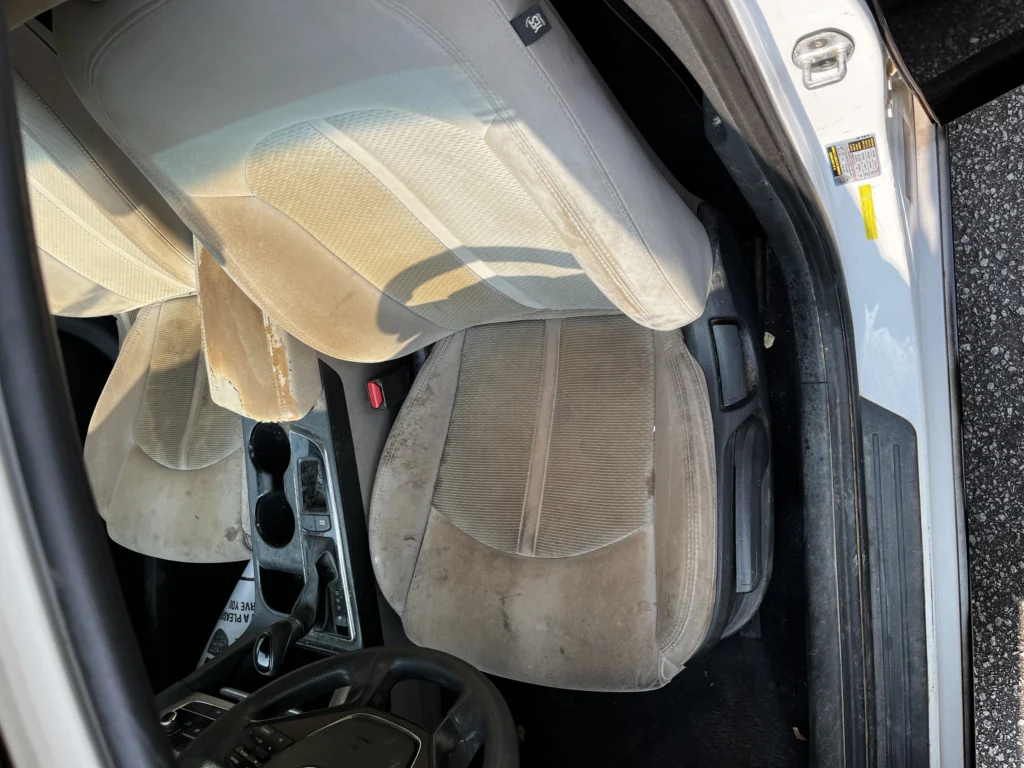 Cloth car seat with heavy staining before a mobile interior detail in Spartanburg SC