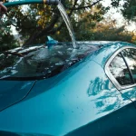 How to wash a ceramic coated car with an open hose flow running water off a coated teal sedan