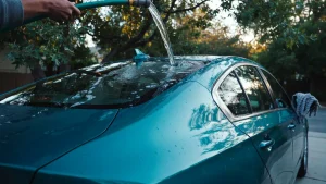 How to wash a ceramic coated car with an open hose flow running water off a coated teal sedan