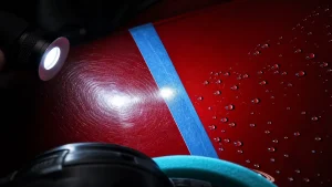 Paint correction vs ceramic coating: swirled red paint beside corrected, water-beaded paint split by a tape line